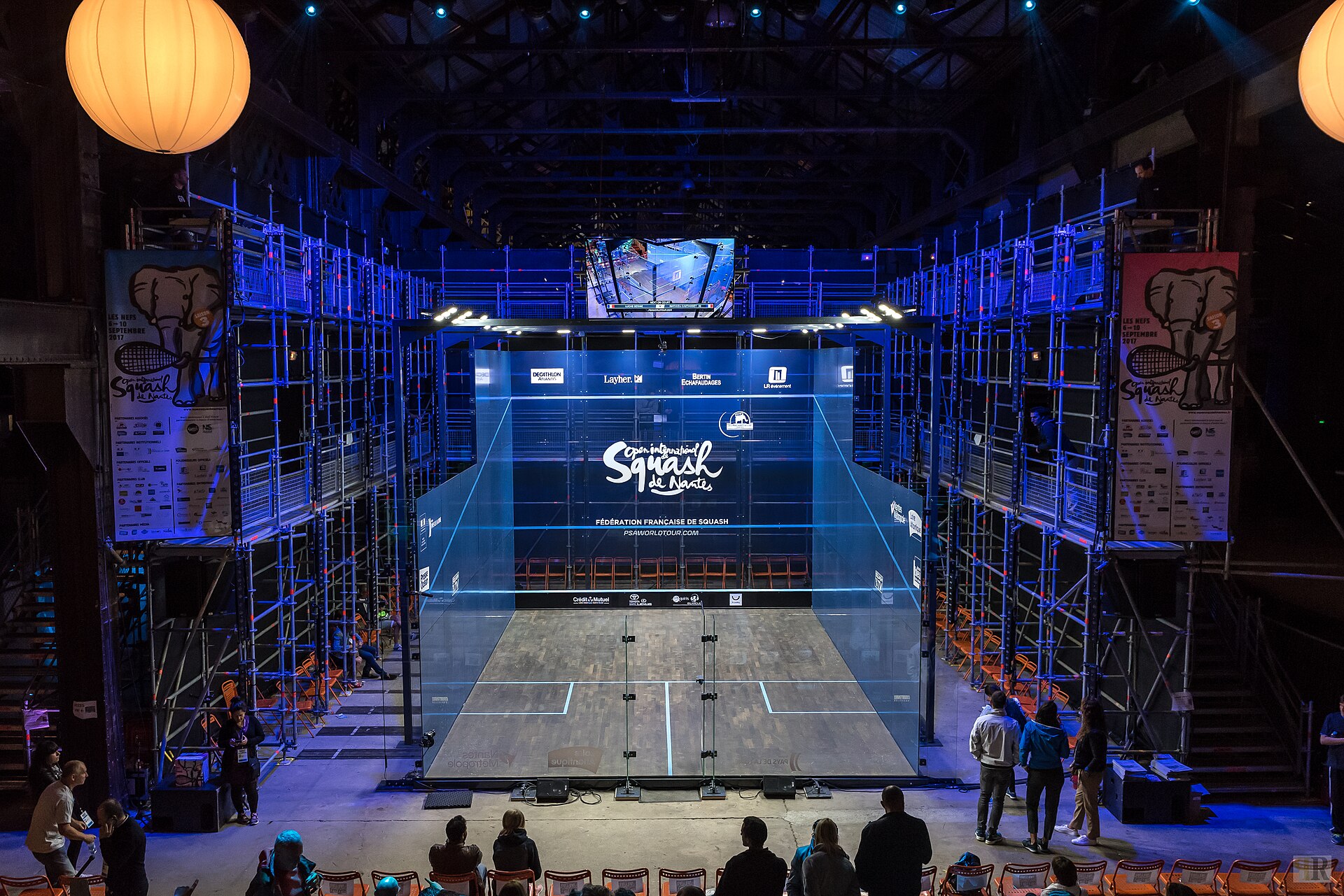 A professional glass squash court set up in an arena